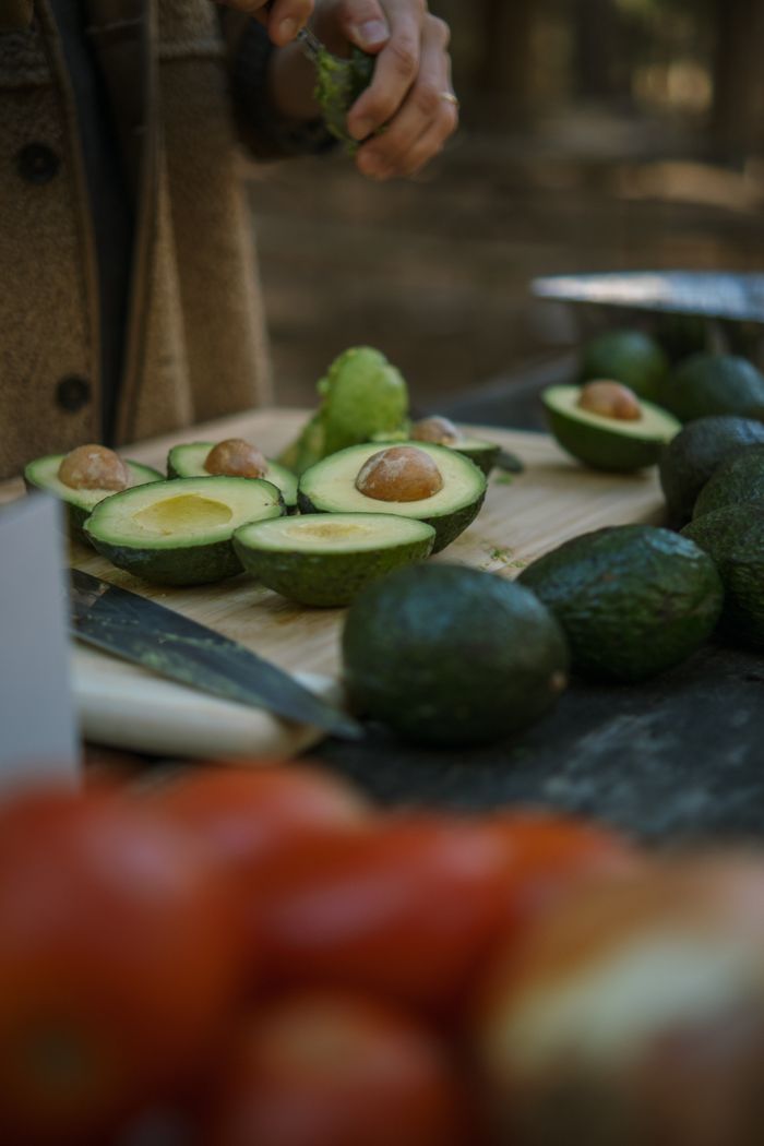 Sliced avocados being prepared outdoors, perfect for fresh guacamole recipes.